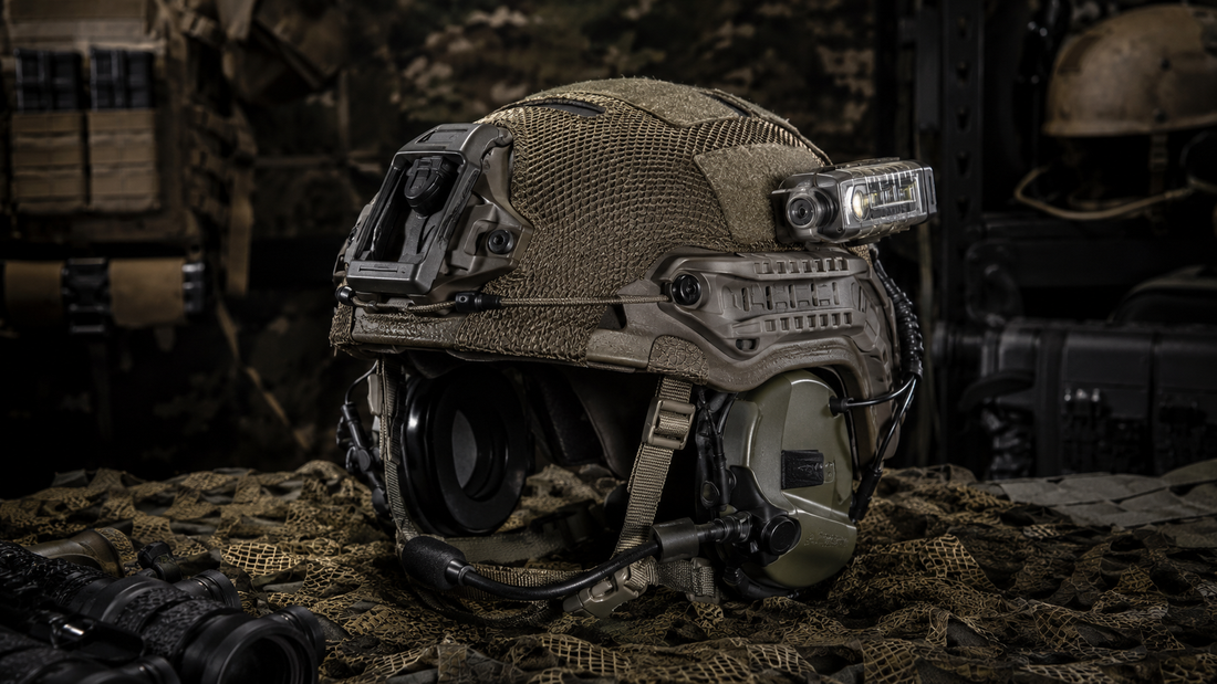 IHPS ballistic helmet with tactical headset, night vision shroud, side rails, helmet cover and mounted strobe displayed in a professional military gear setup.