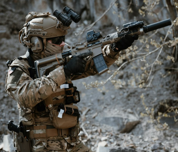 military operator wearing tactical helmet with mounted light aiming rifle outdoors